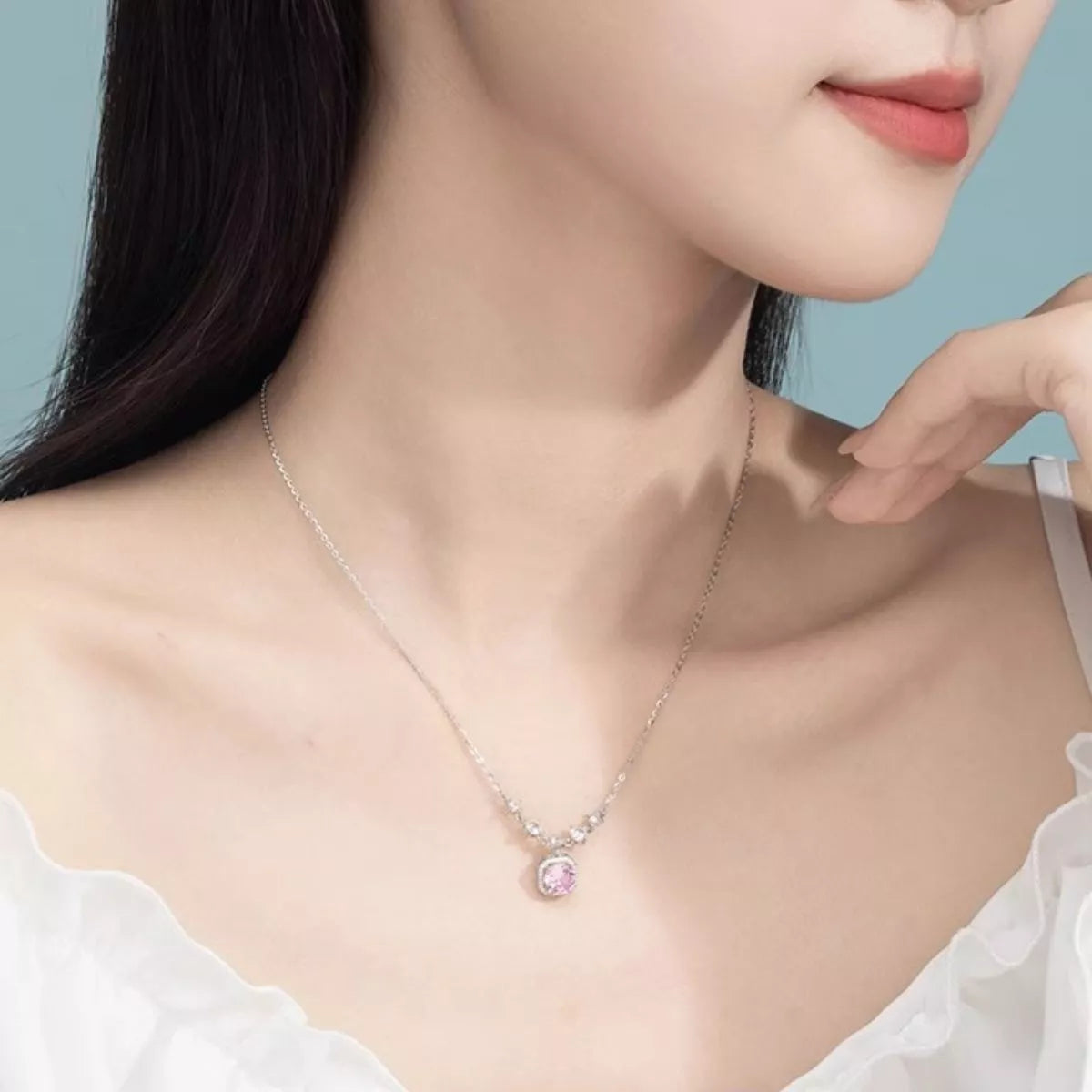 Blush pink zircon pendant necklace with silver chain and small clear stones on model