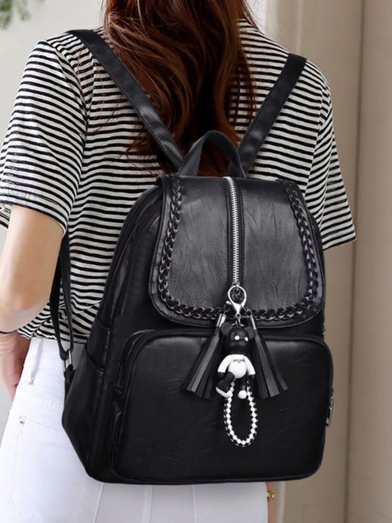 Black leather backpack bag with braided trim, front flap pocket and tassel keychain