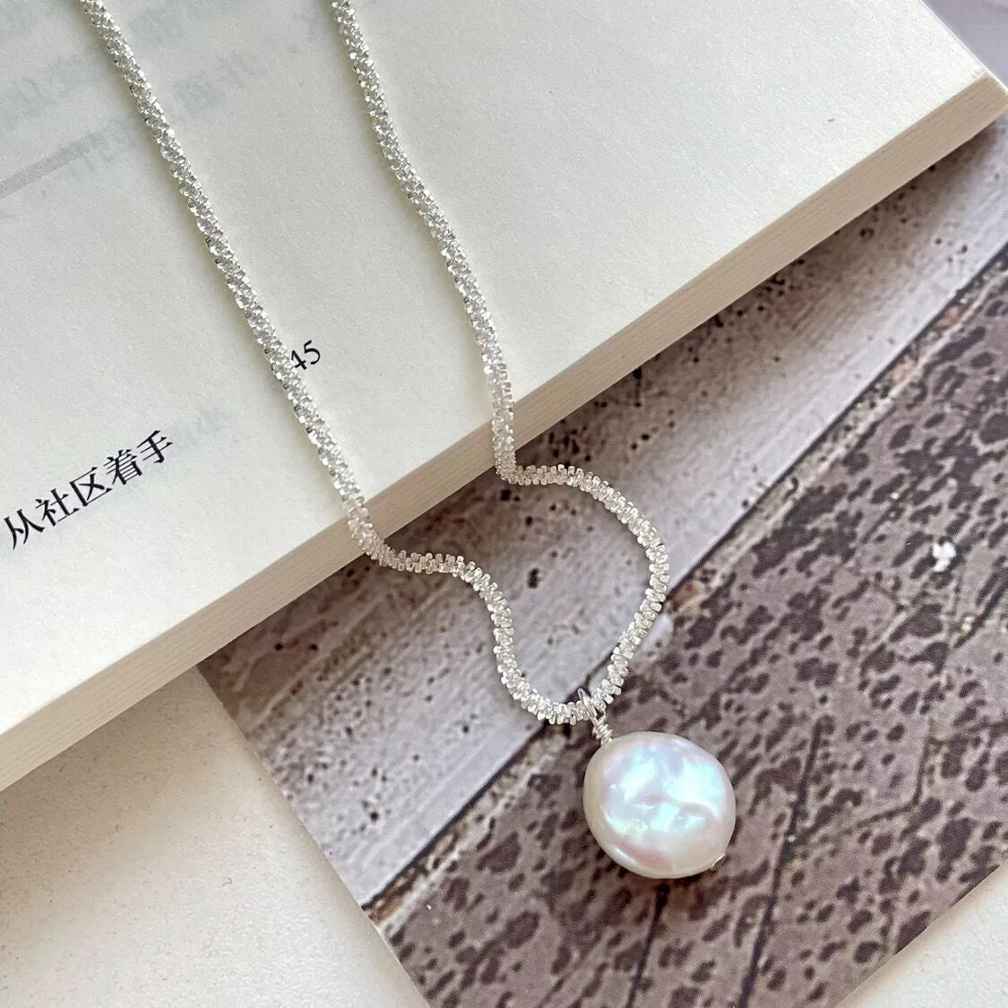 Silver chain pearl necklace with heart-shaped links and round pearl drop