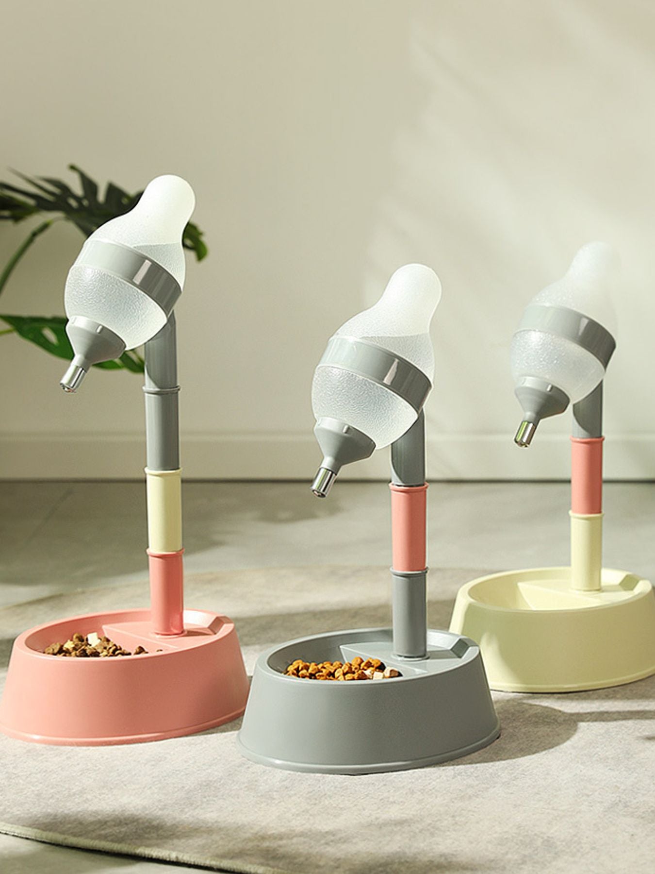 Pet water dispenser bowls in pink, gray, and beige with adjustable height nozzles