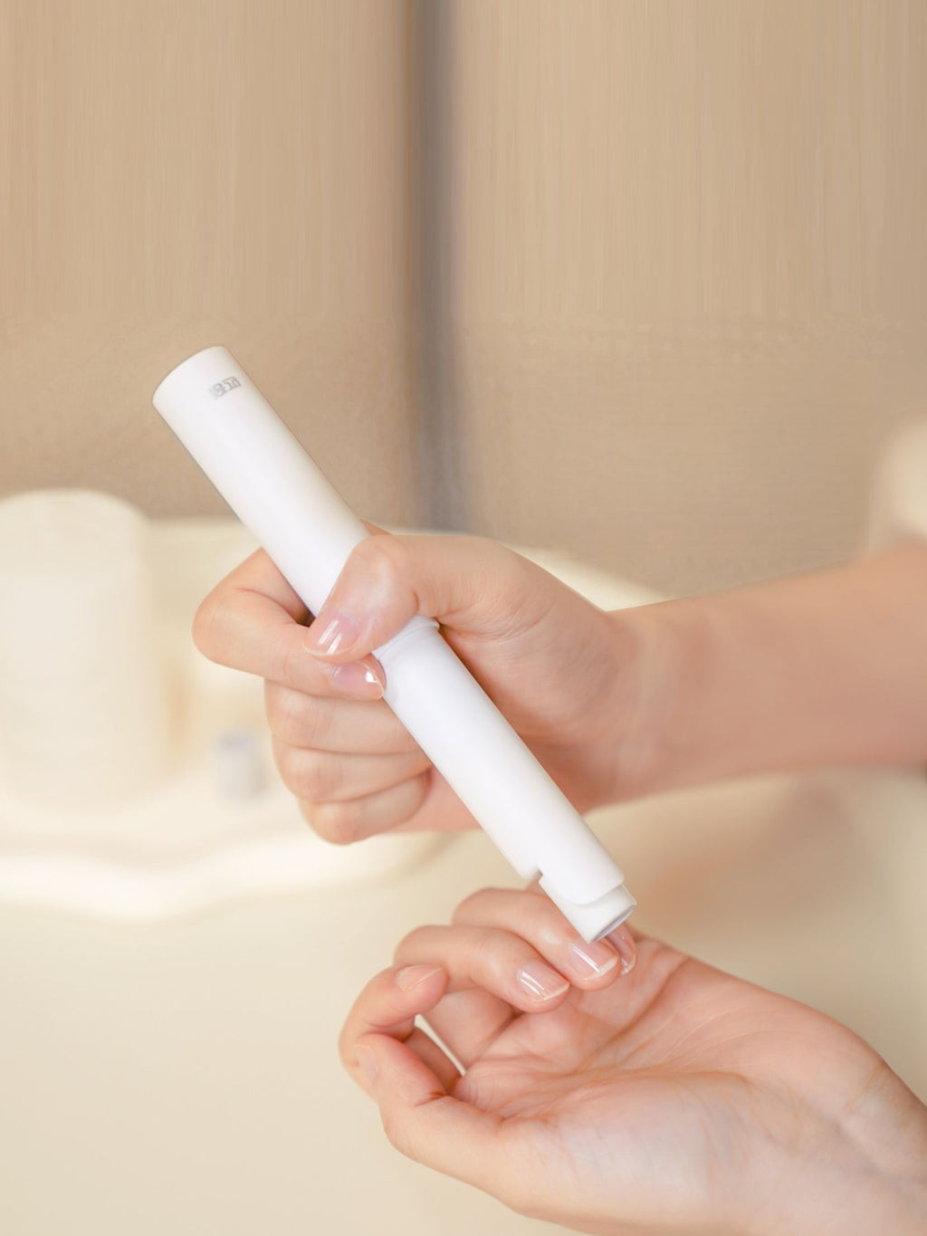 White handheld electric nail buffer, device held for buffing