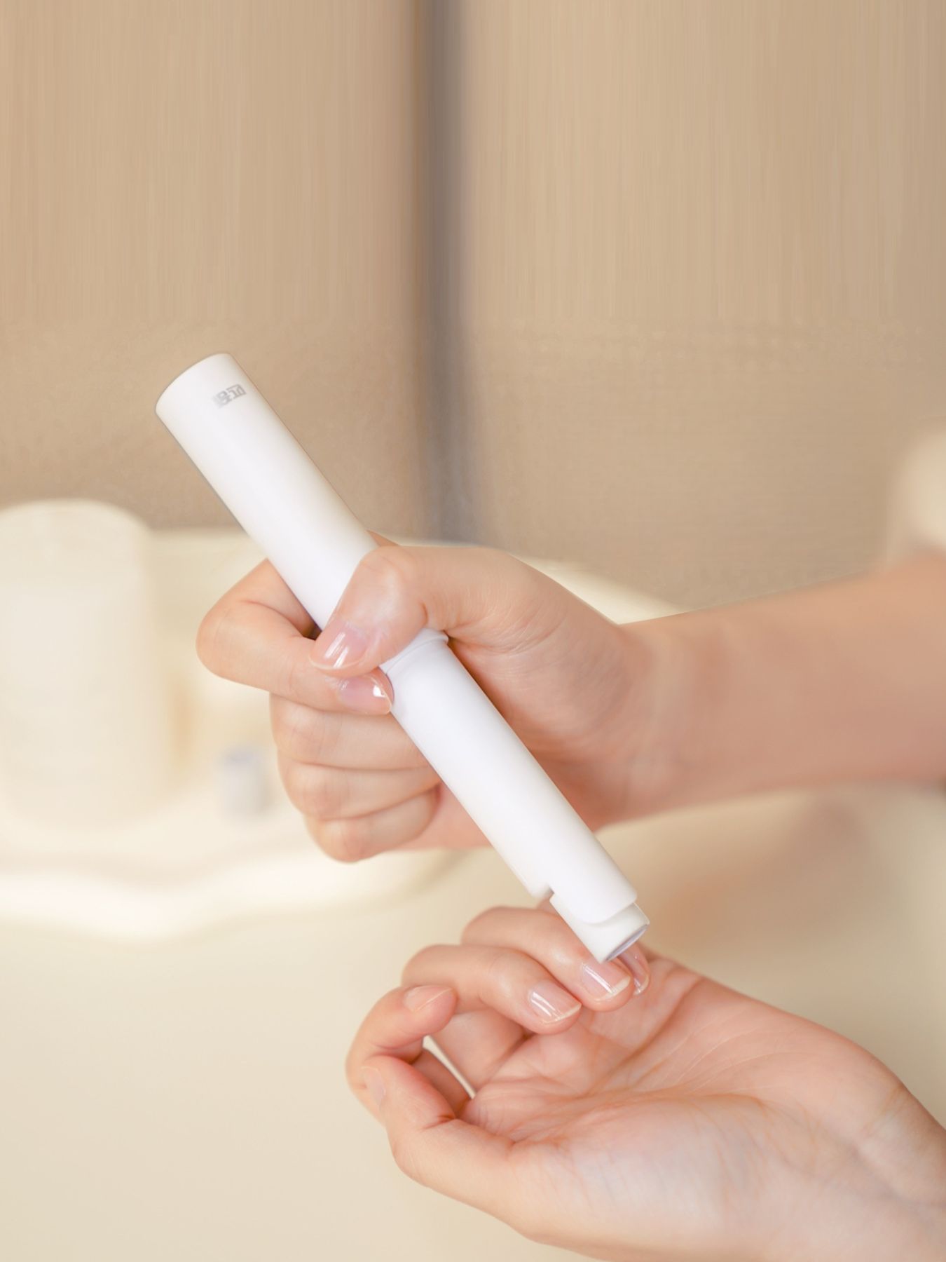 White handheld electric nail buffer, device held for buffing