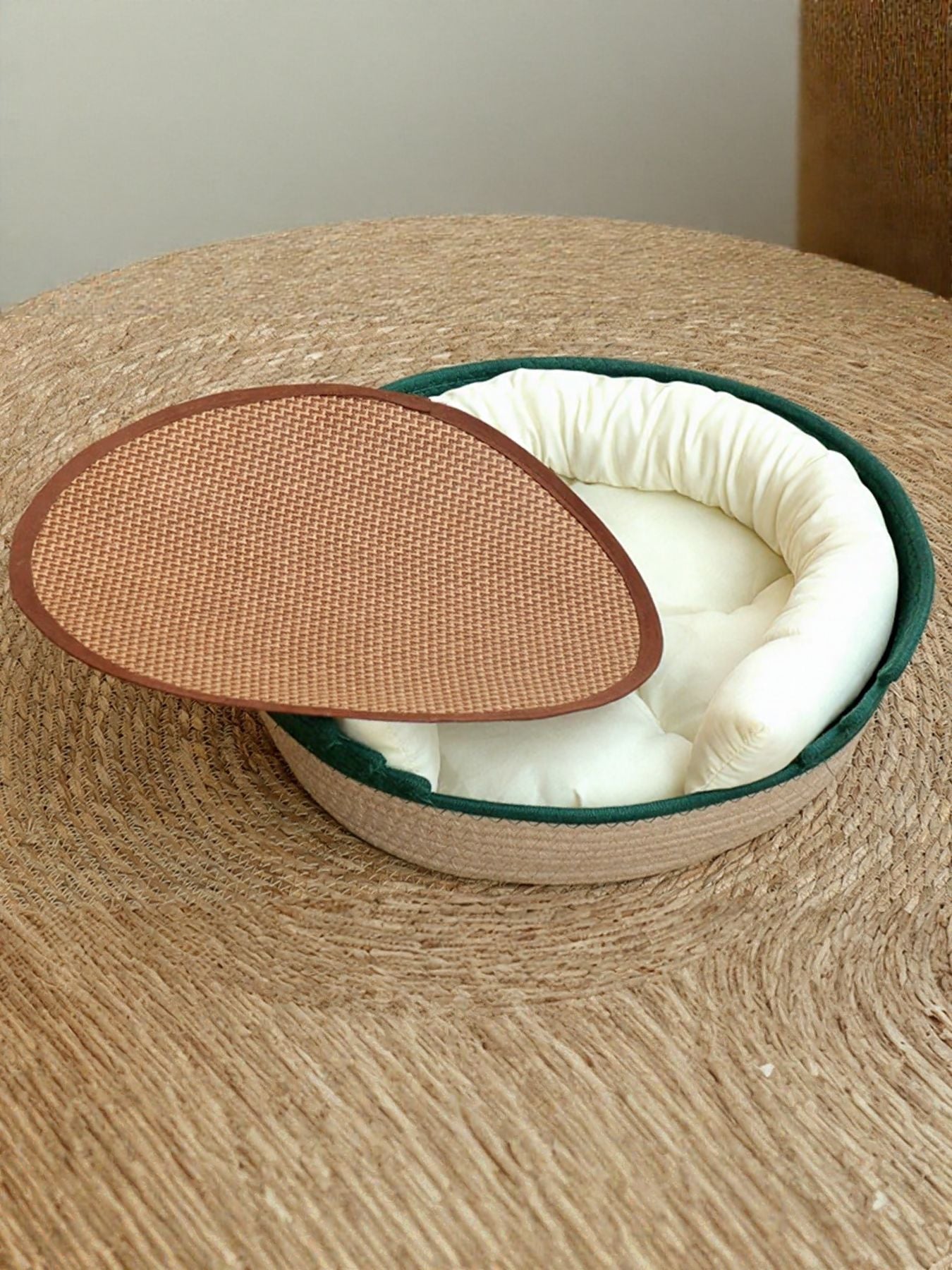 Woven Pet Nest with white cushioned insert and green woven rim, oval basket