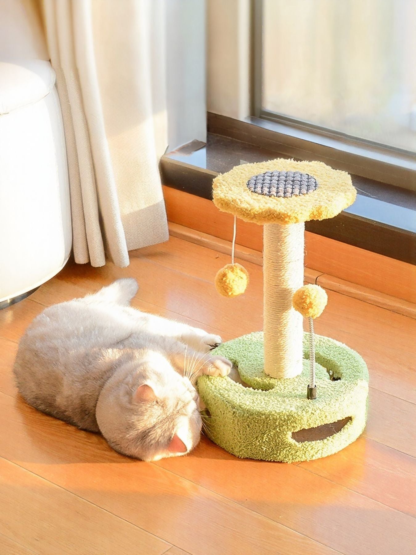 Cat scratching post with dangling balls in yellow and green, with plush circular scratching pad