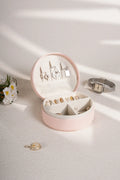Blush pink PU leather travel jewelry box open, jewelry arranged in molded sections