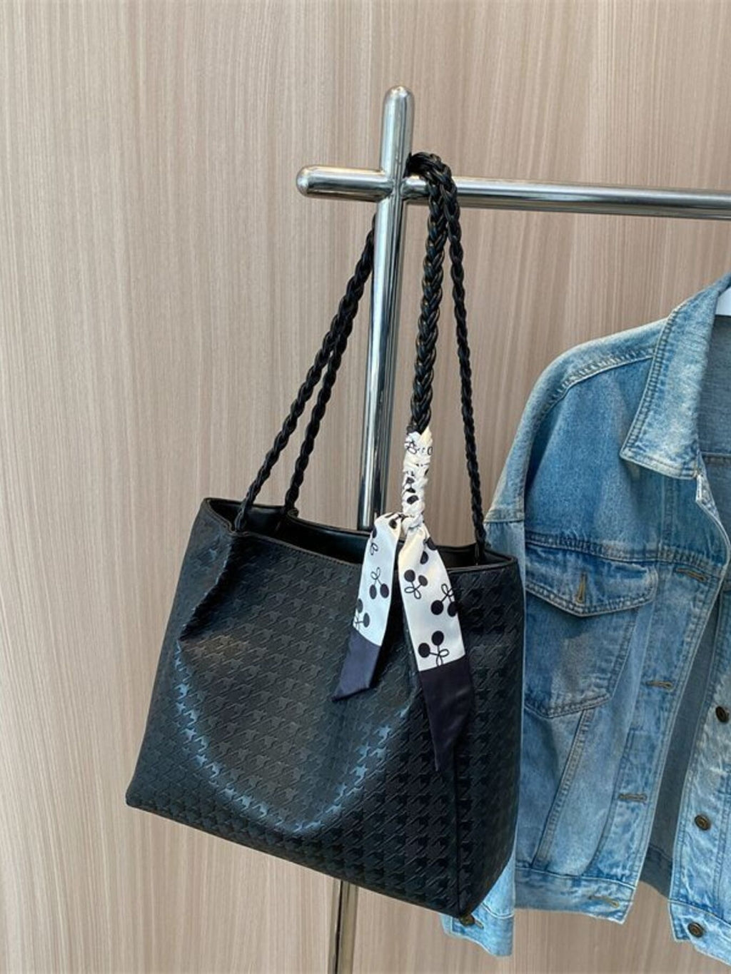 Black braided handle tote bag with bow ribbon and textured pattern