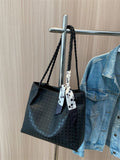 Black braided handle tote bag with bow ribbon and textured pattern
