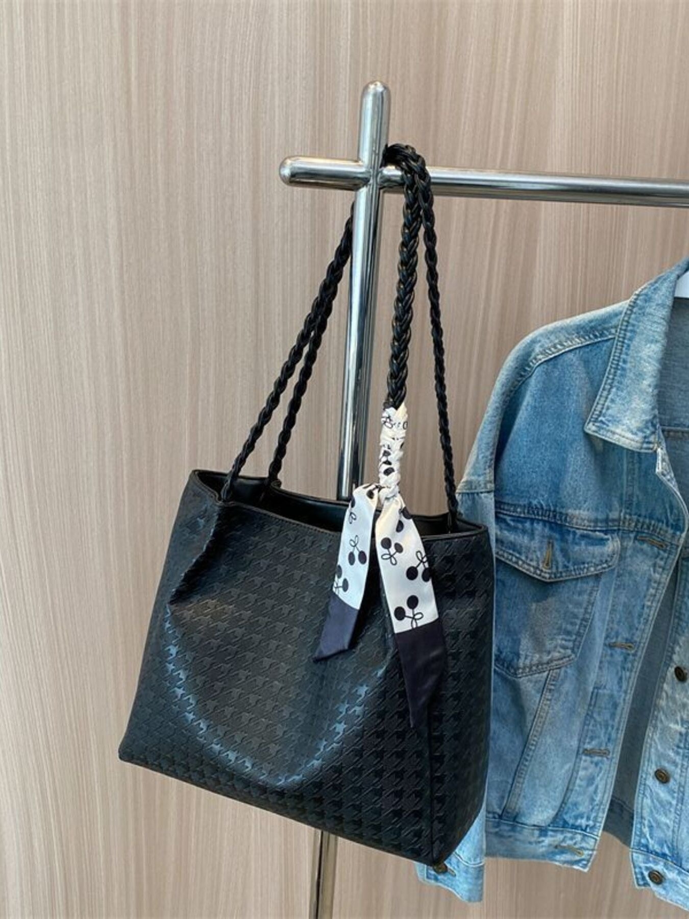 Black braided handle tote bag with bow ribbon and textured pattern