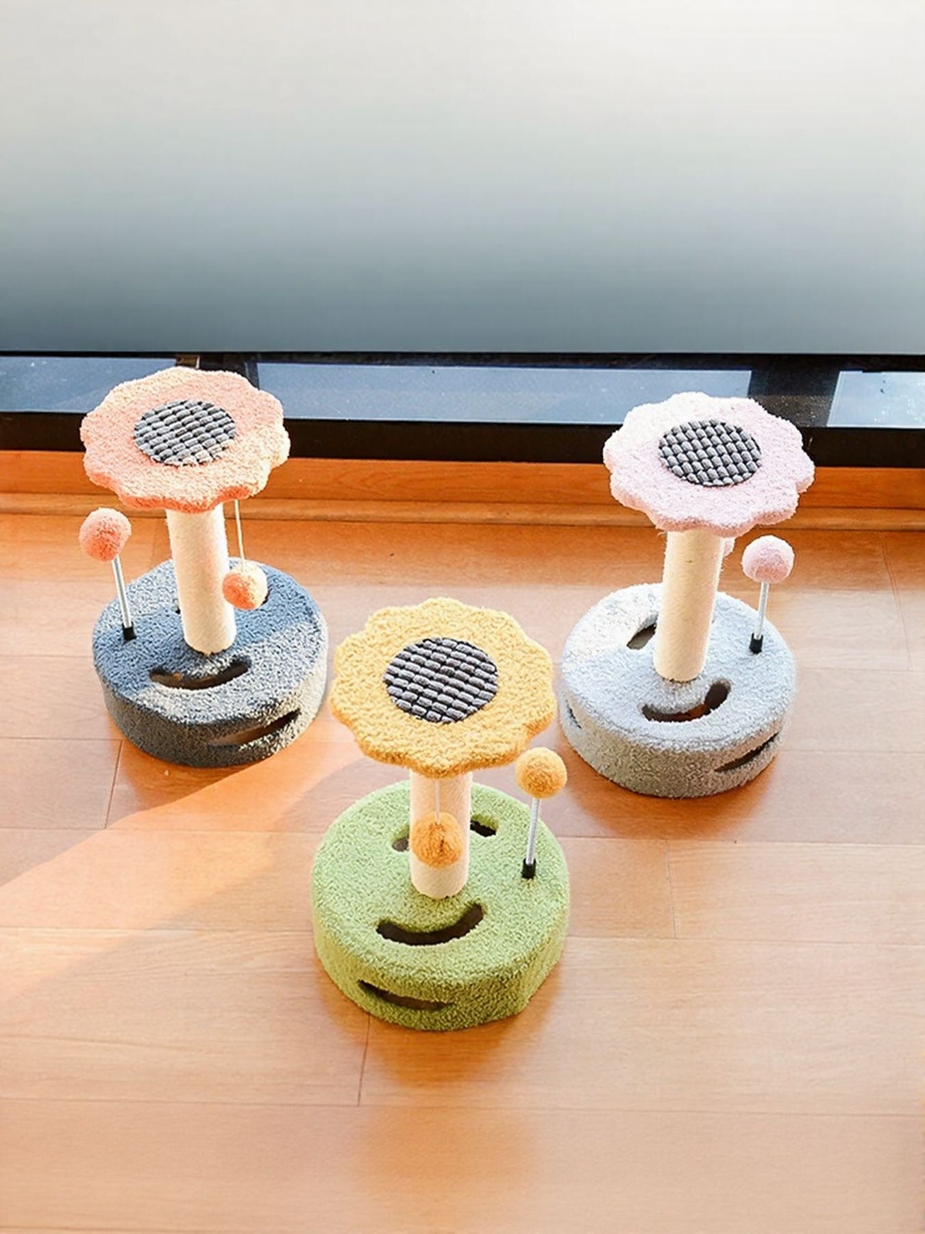 Set of cat scratching posts with dangling balls in orange+dark blue, yellow+green, and pink+blue