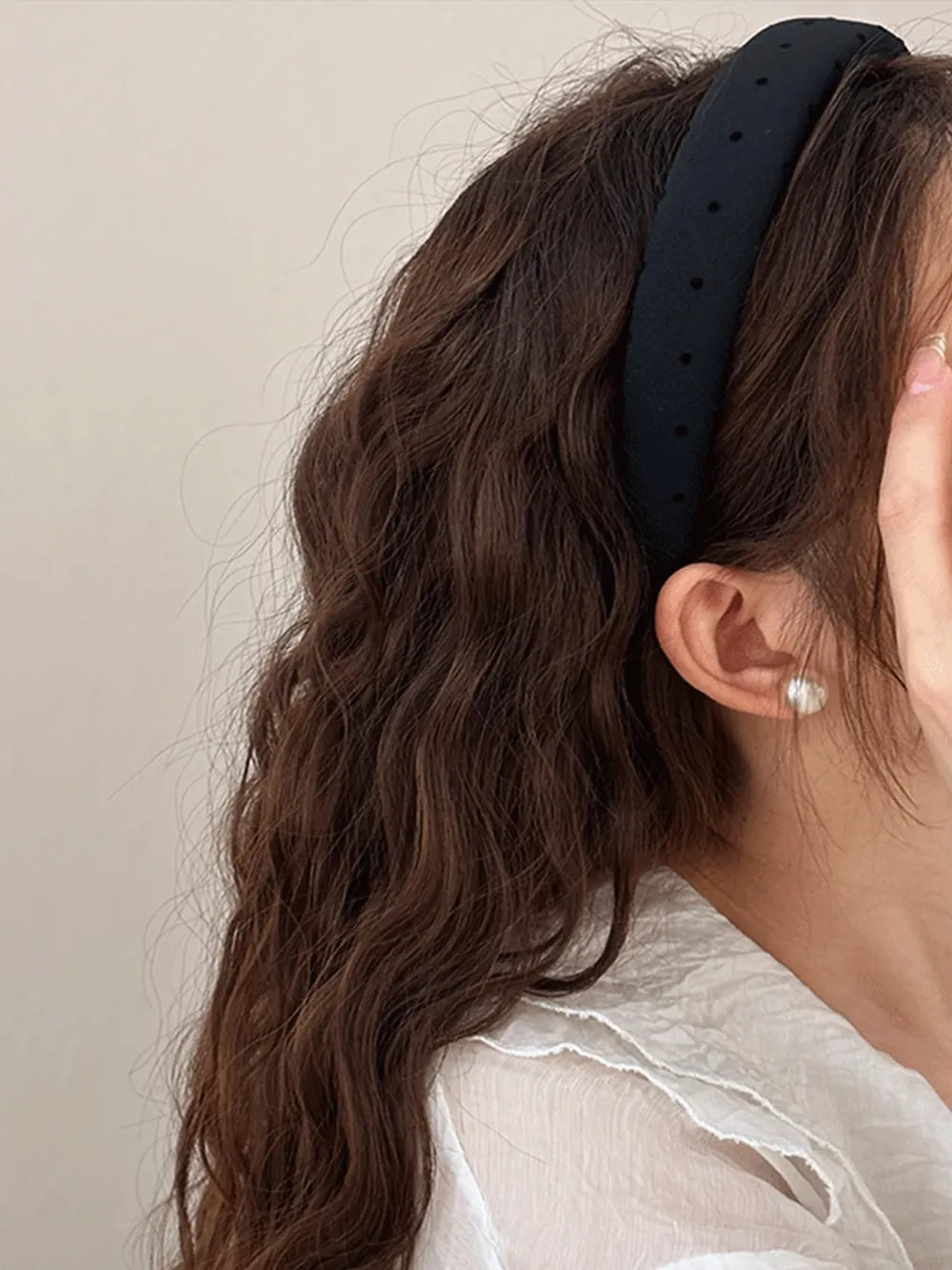 Black polka dot wide headband worn on hair with dark dot pattern