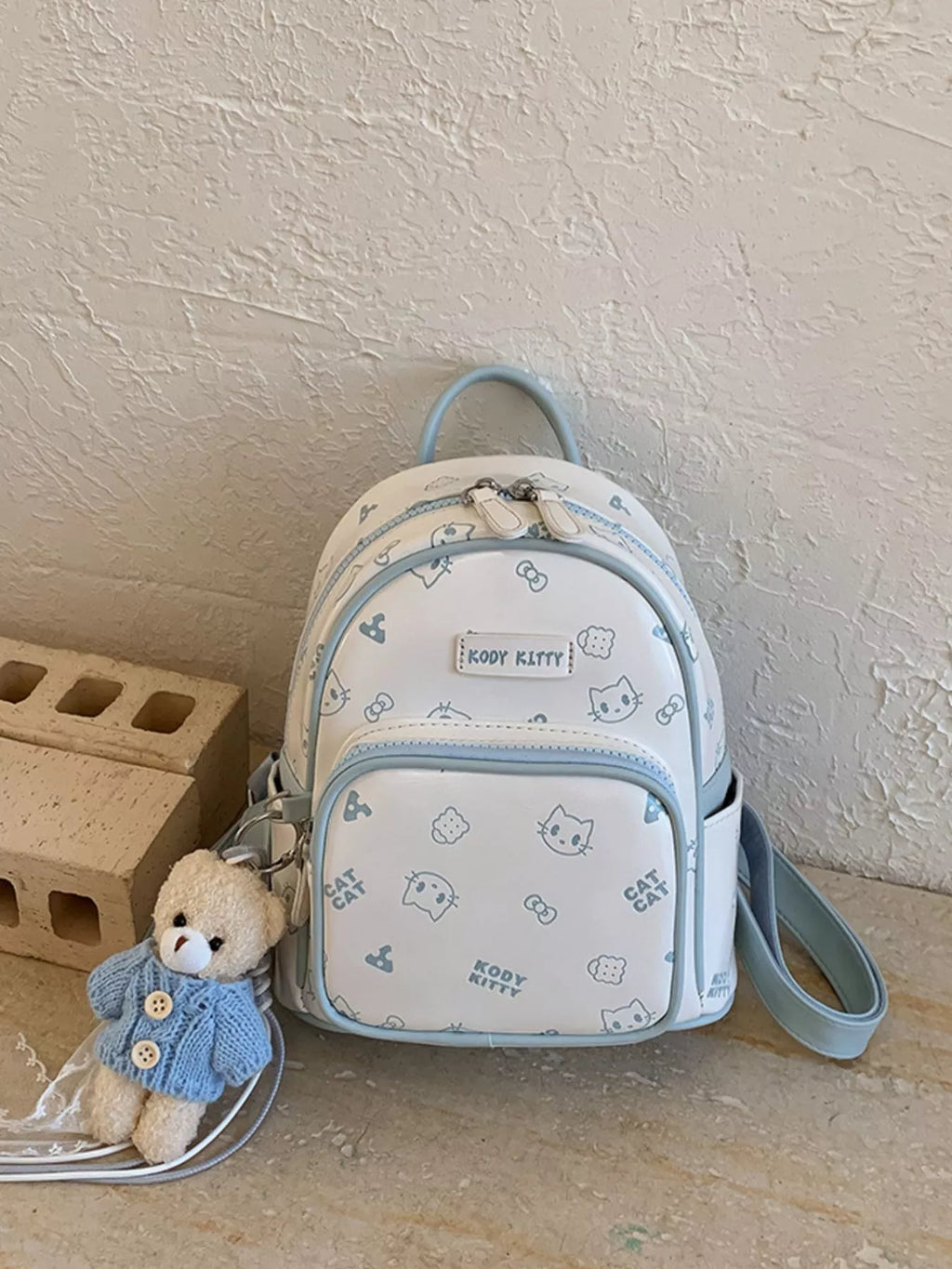 Pastel blue cartoon cat backpack with side crossbody strap and front pocket