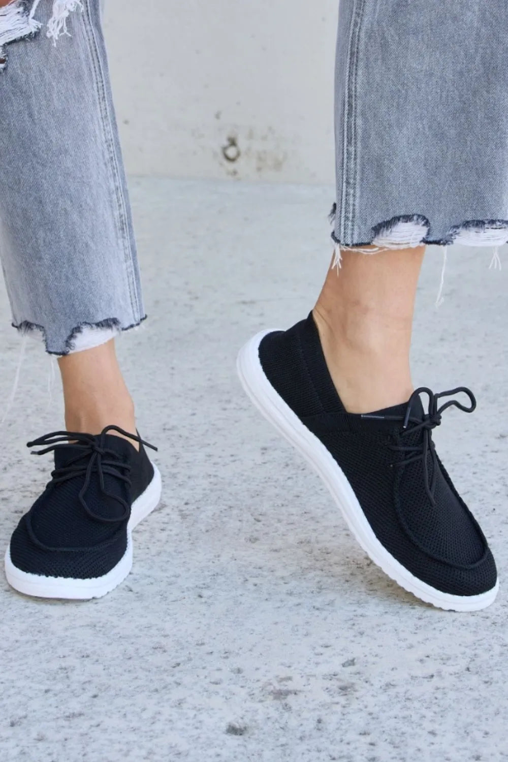 Black lace-up flat sneakers, round toe, white midsole and outsole