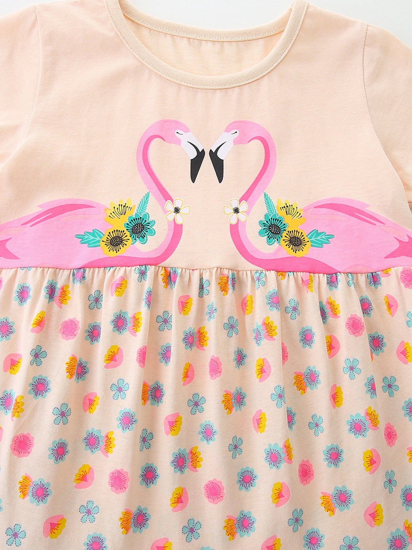 Close-up of flamingo graphic and tiered skirt on eggshell casual dress
