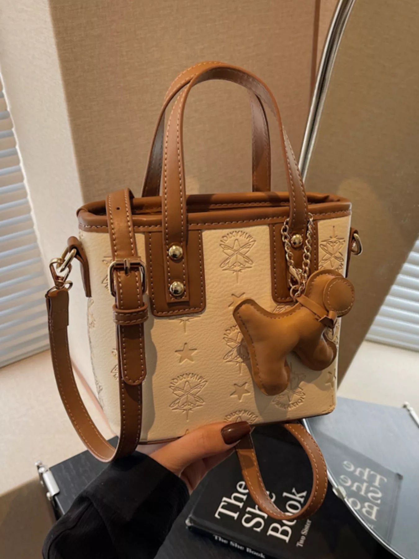 Beige Handtasche mit Relief-Prägung, braunen Trägern, Ketten-Anhänger und Hund-Charm