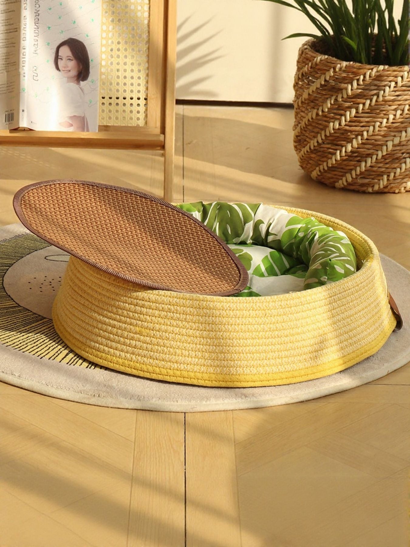Woven rattan pet nest with yellow woven rim, green leaf cushion, brown oval lid