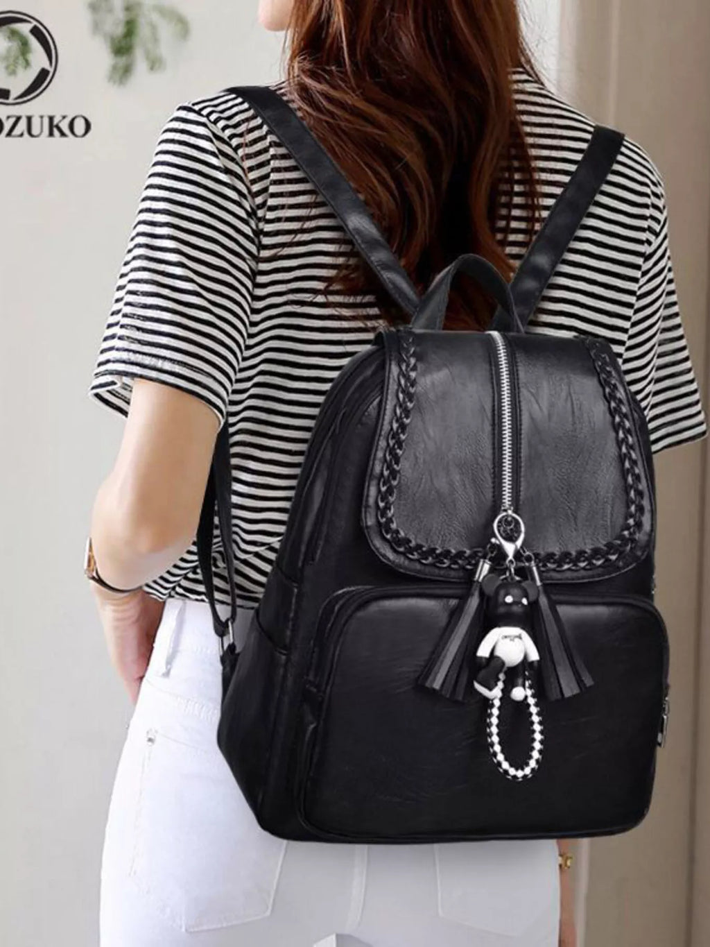 Black leather backpack bag with front flap, zipper closure and braided chain trim