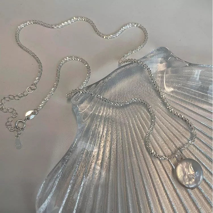 Silver pearl necklace with layered chain and round pearl charm details
