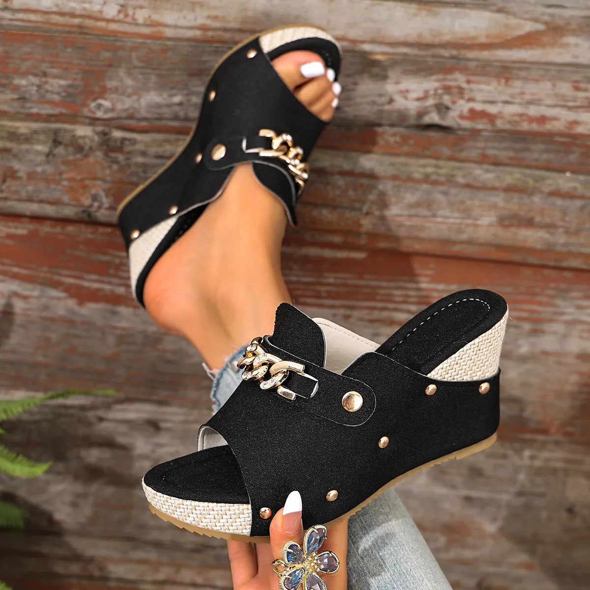 Black open-toe wedge sandals with stud accents and gold-tone chain strap over suede upper