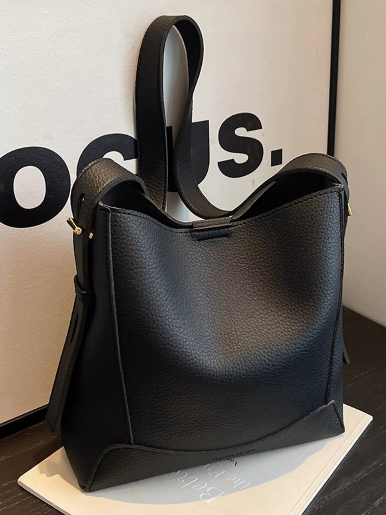 Black leather crossbody bag with adjustable strap and zip-top closure