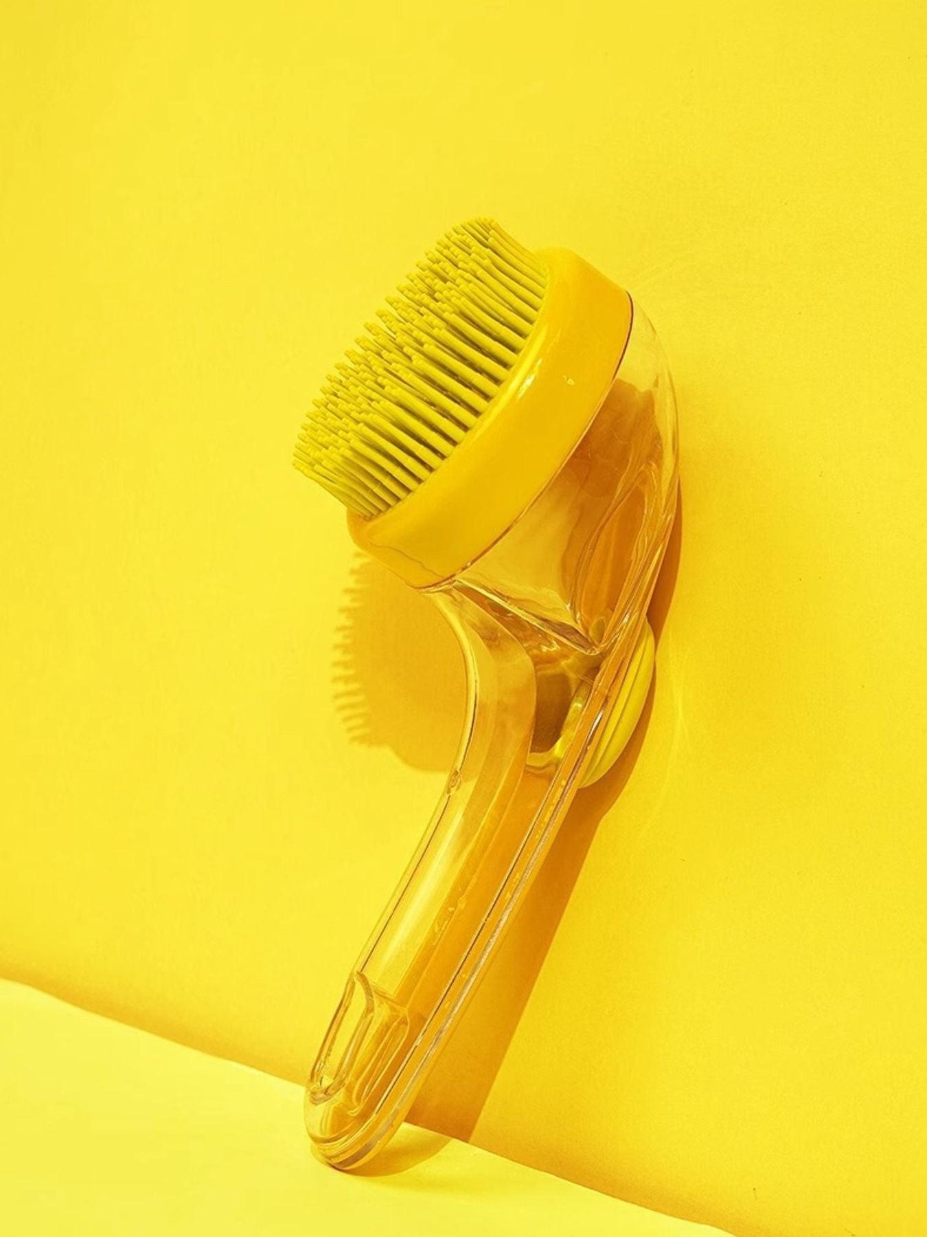 Soft Pet Shower Brush in Yellow, round head with flexible bristles on a clear handle
