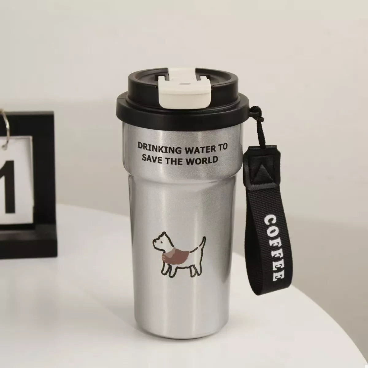 Black stainless steel tumbler with straw, cat graphic, 'DRINKING WATER TO SAVE THE WORLD'