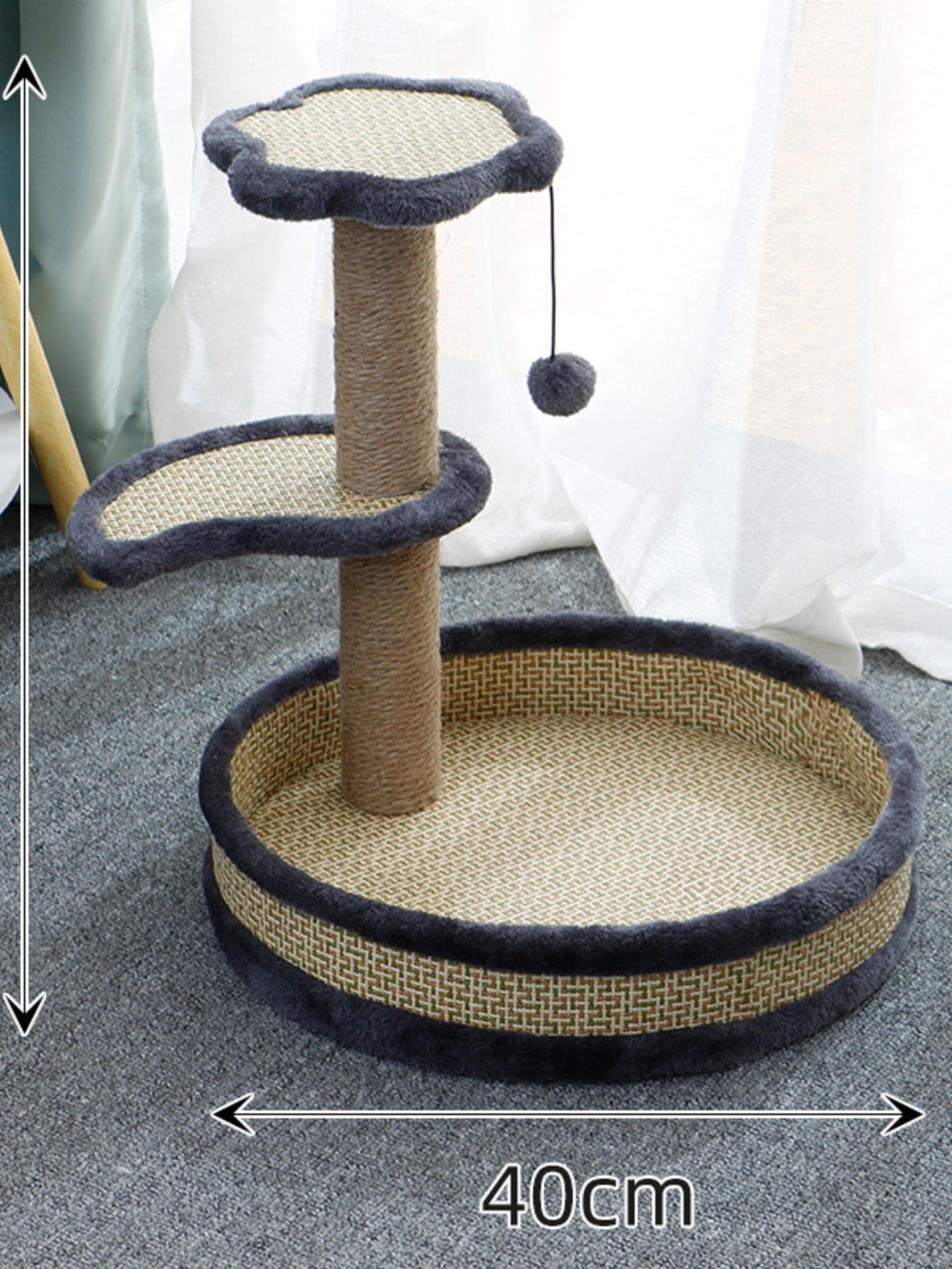 Gray woven cat scratching post with circular bed, dark blue padded border, hanging pom-pom