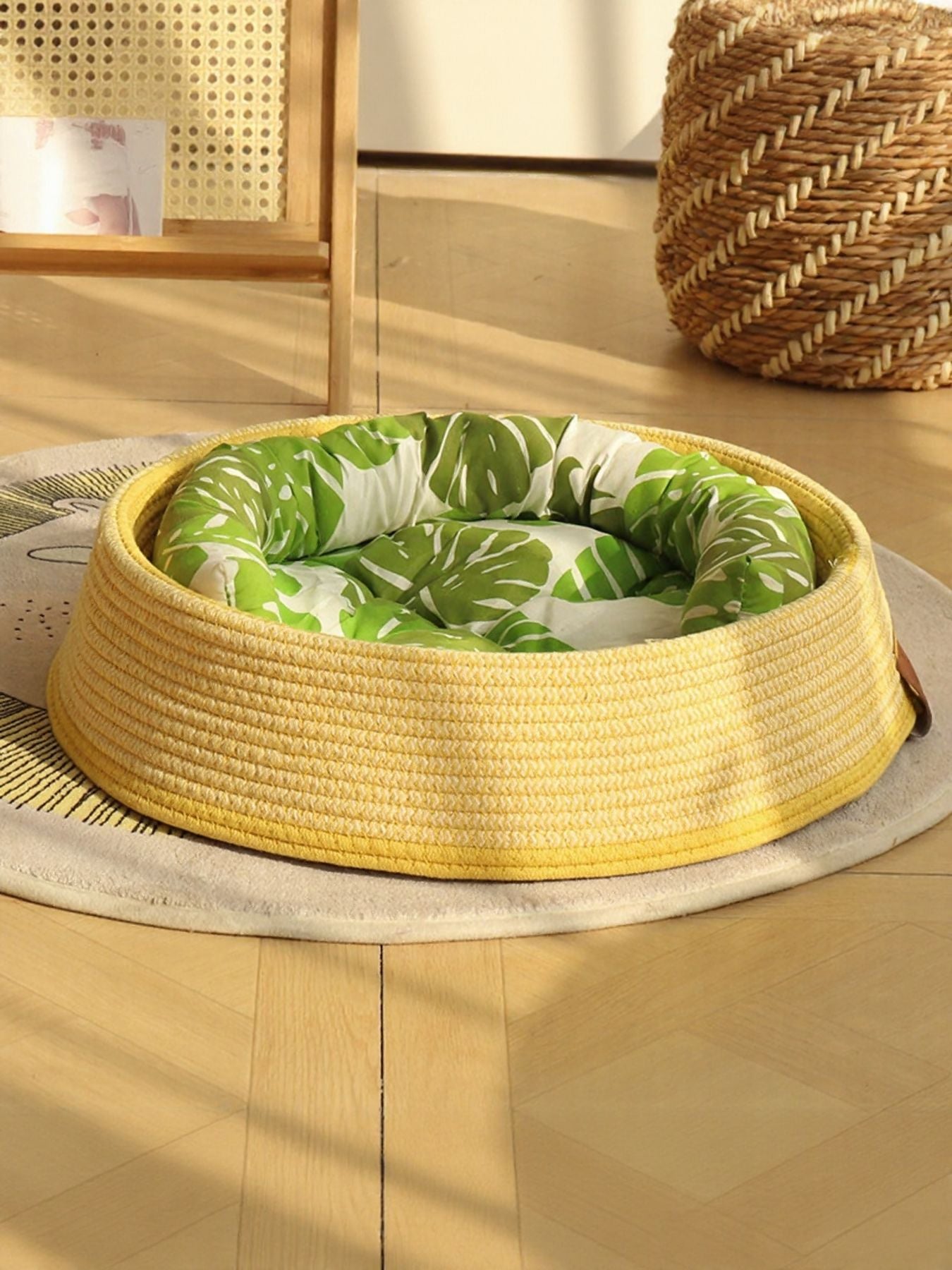 Woven rattan pet nest with yellow woven base and green leaf-pattern inner cushion