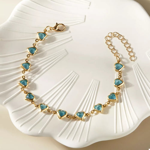 Gold heart bracelet with teal heart charms, linked chain and secure clasp