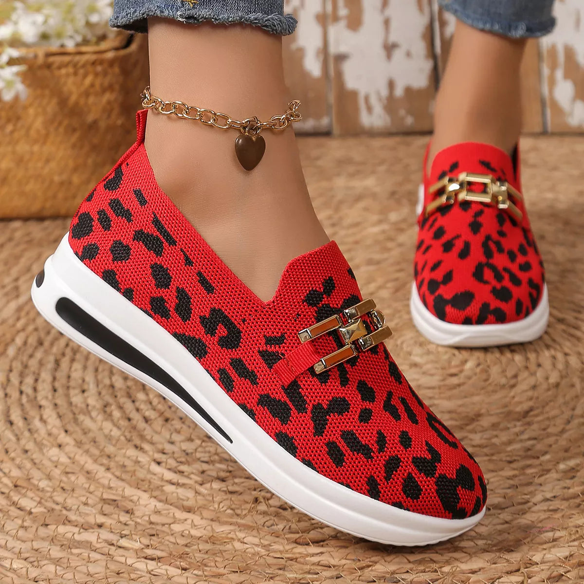 Red leopard slip-ons with gold buckle across vamp and white athletic sole
