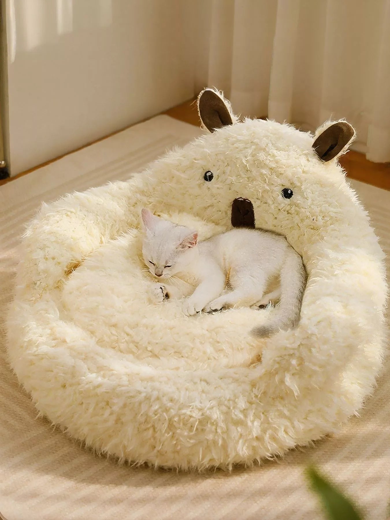 Cream bear plush pet nest with cat curled inside, cozy ring bed