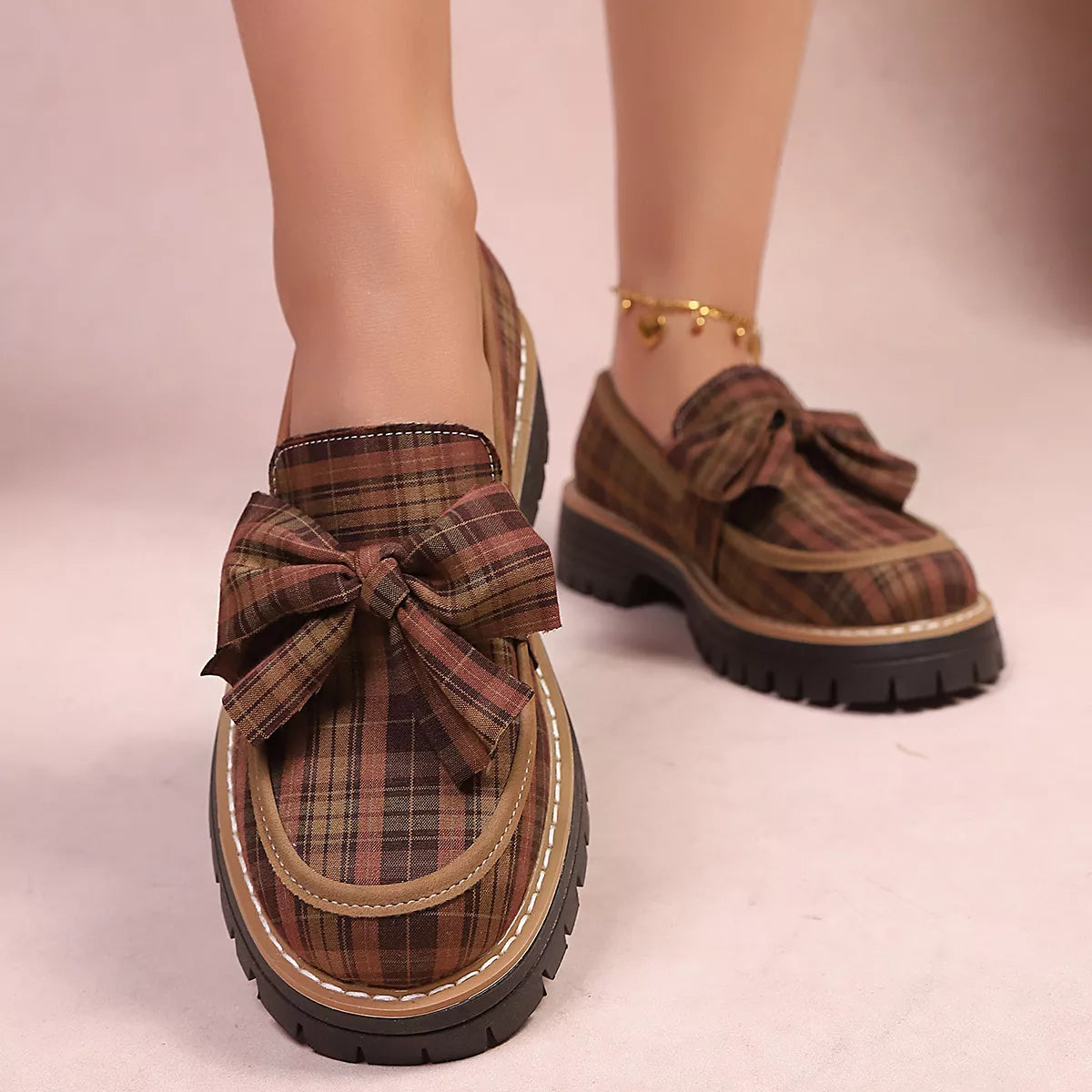 Tan plaid chunky loafers with side bow detail and thick black tread sole