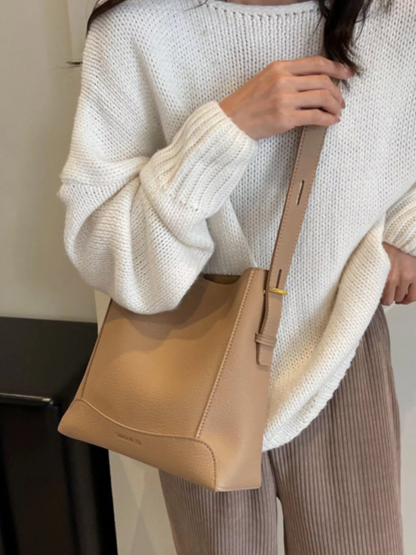 Khaki leather crossbody bag with adjustable long strap and zip-top closure