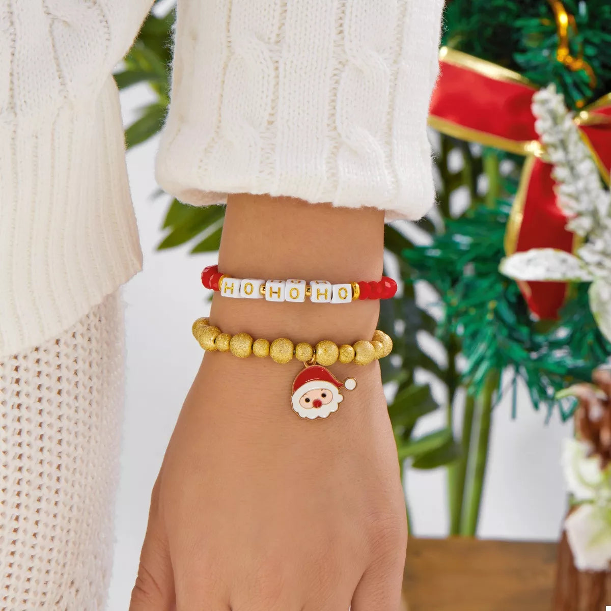 Red HO HO HO bead bracelet with gold beads and Santa charm on wrist