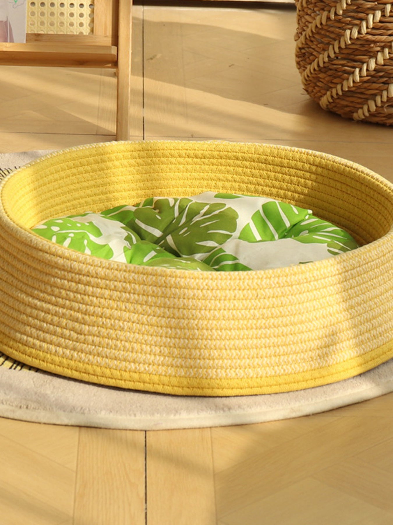 Woven rattan pet nest: yellow woven sides with white cushion and green leaf pattern