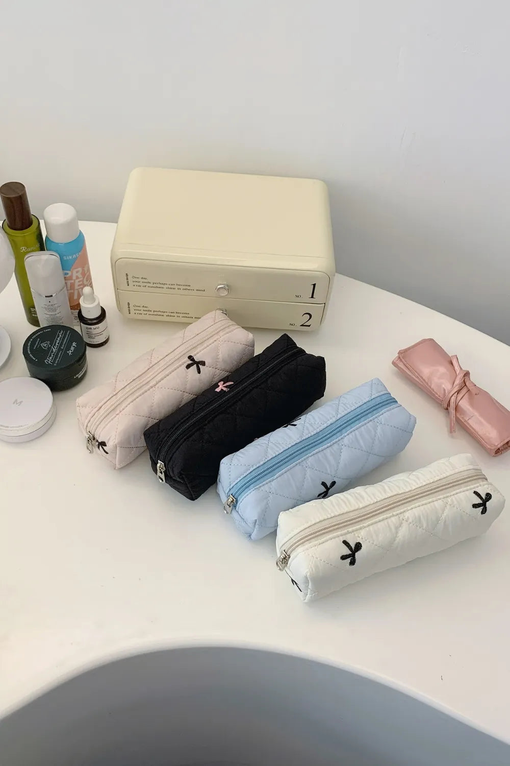 Quilted storage bag set display in white, black, light blue, blush pink with bow print