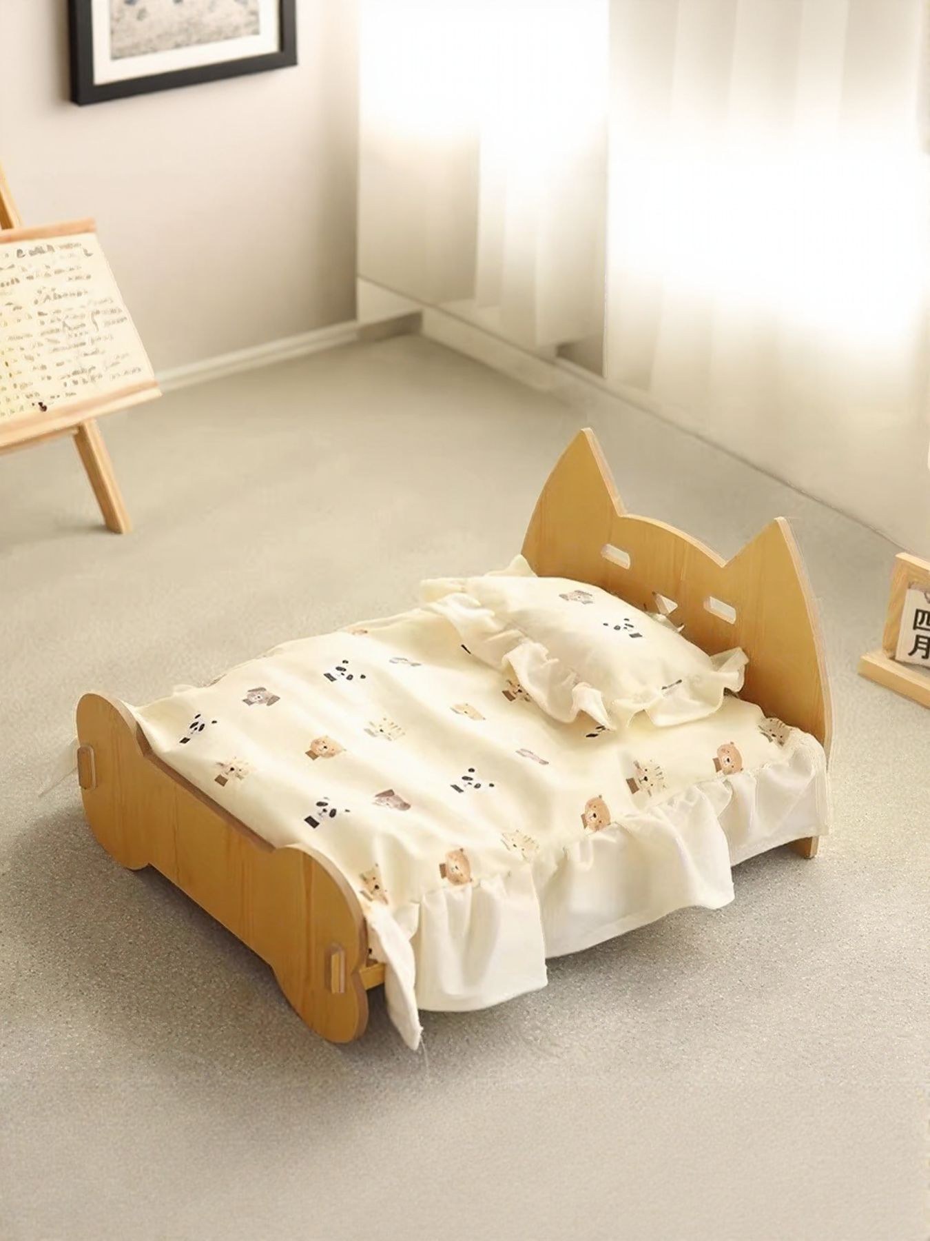 Wooden pet bed for pets with bear-pattern blanket laid across the base.