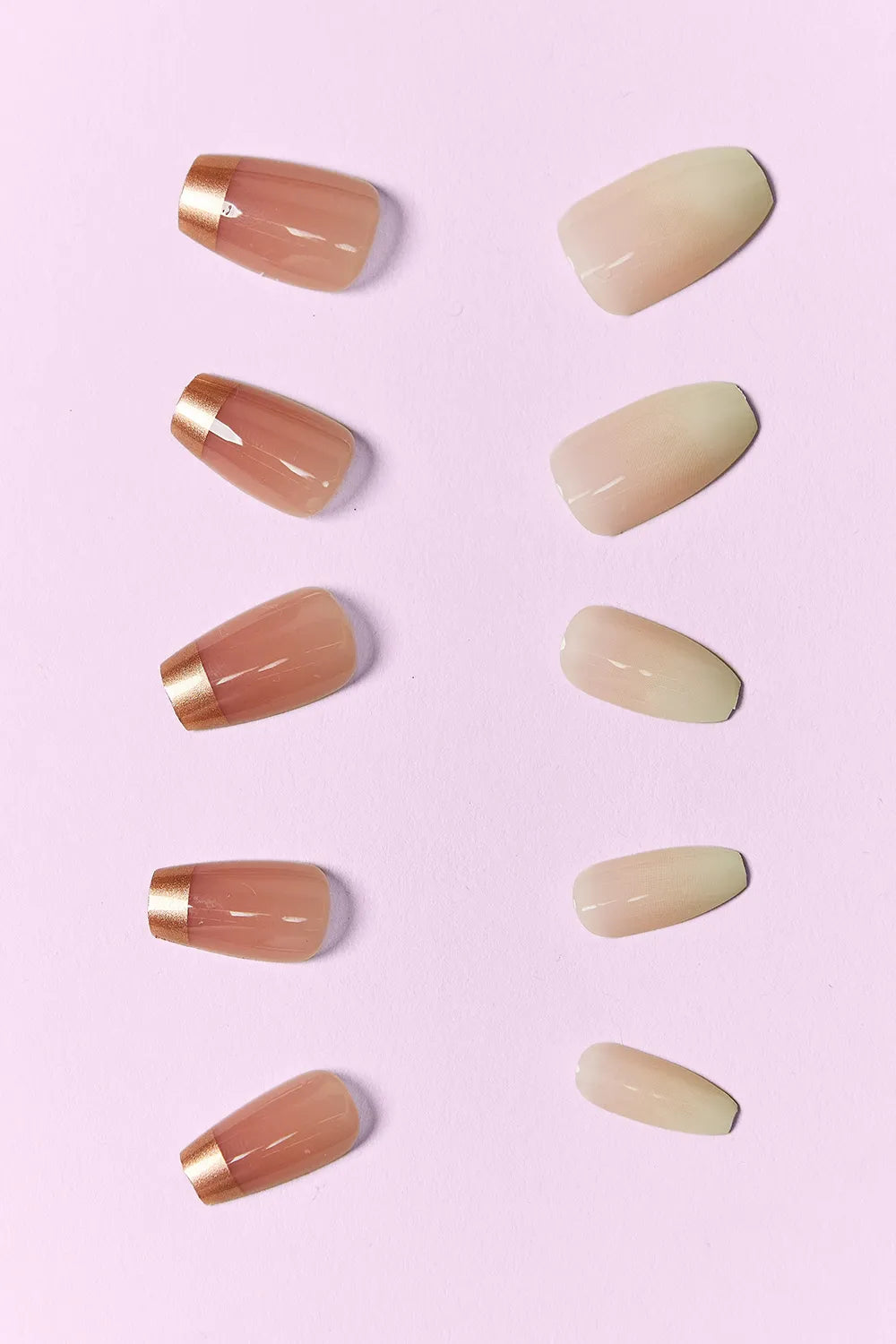 Press-on nail tips in warm nude and brown tones with gold foil accents