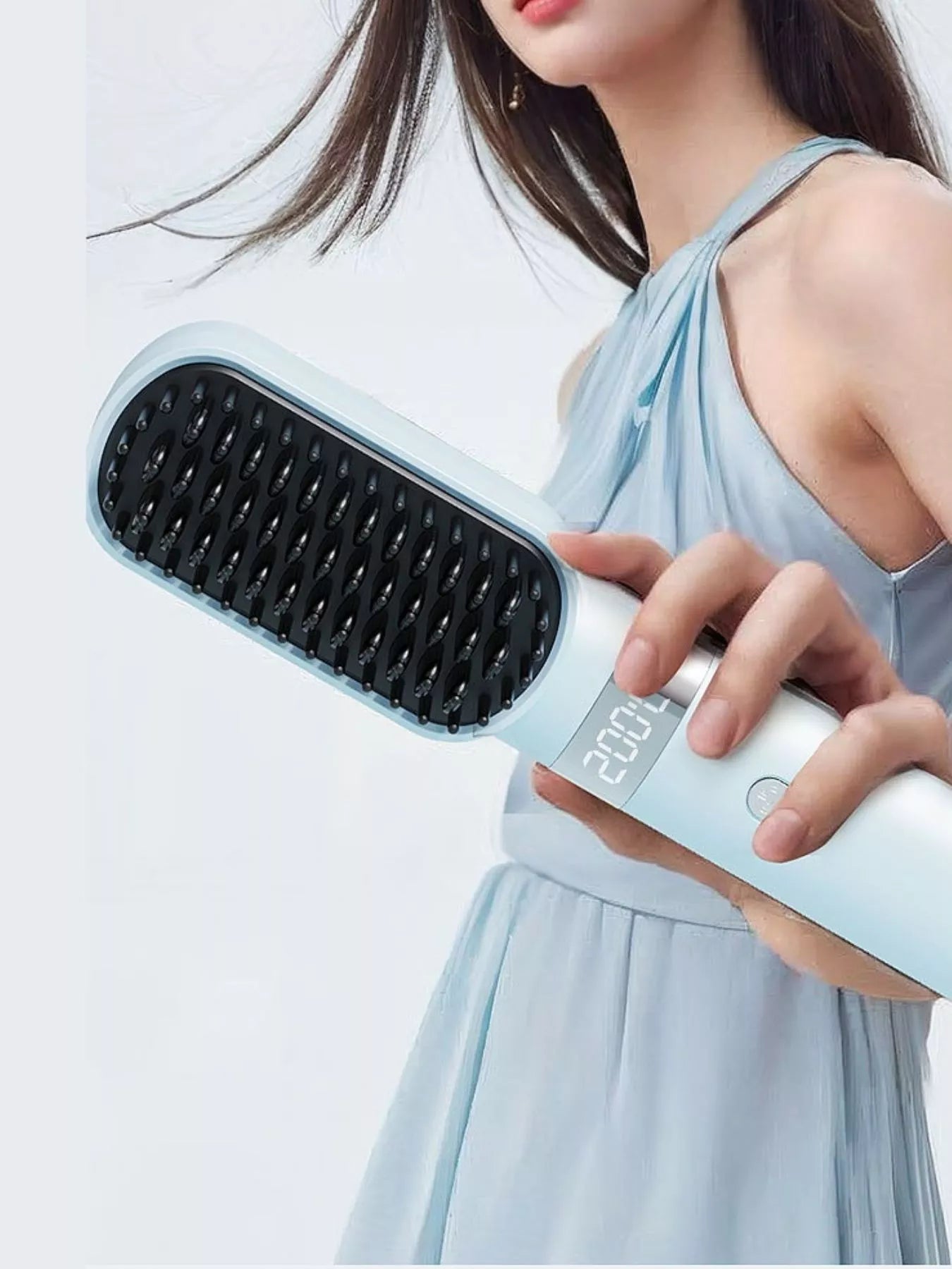 Light blue heated straightening comb held near long hair; LCD shows 200°C