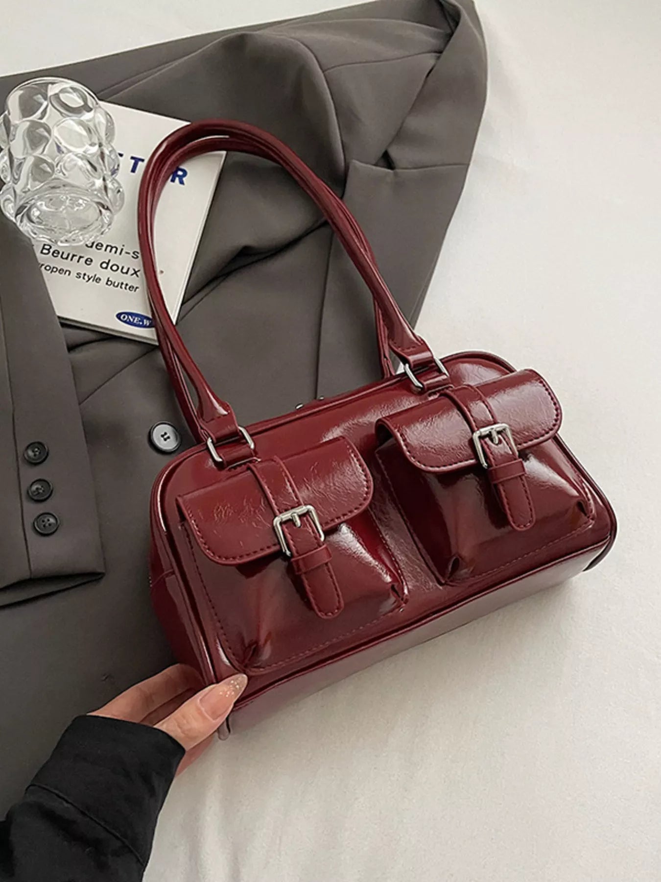 Vintage buckle shoulder bag in deep red, glossy finish, front flap with buckles