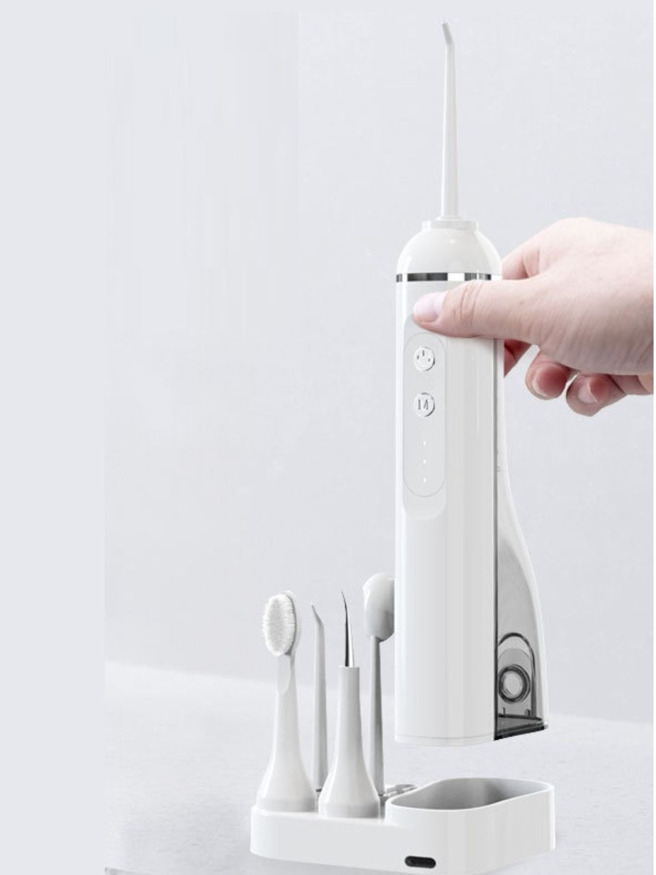 Hand holding white water flosser handle with front control buttons