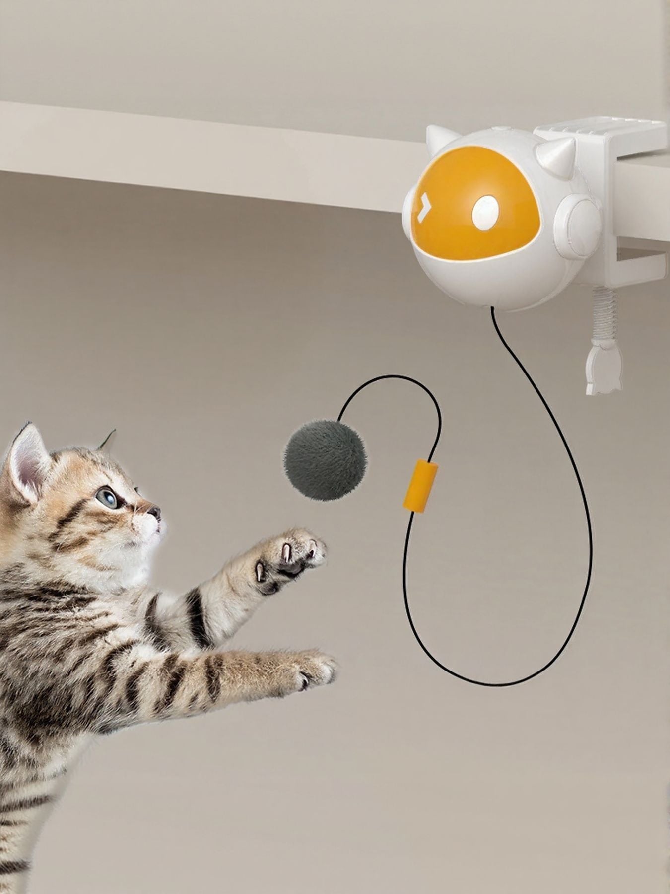 Interactive hanging cat teaser toy with yellow window ball, black cord, and gray pom ball