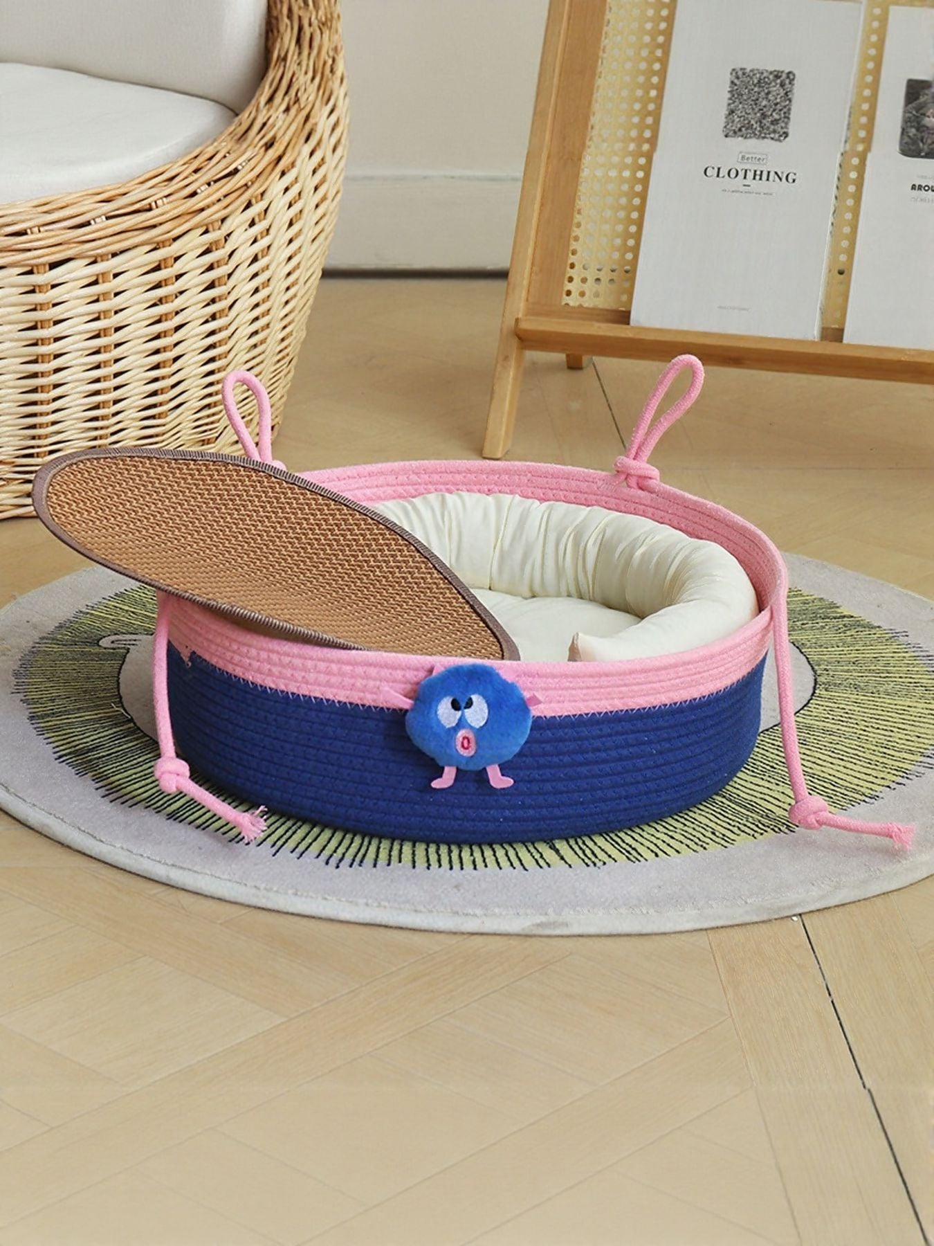 Two-tone woven pet nest with blue sides, pink trim, and beige cushioned inner