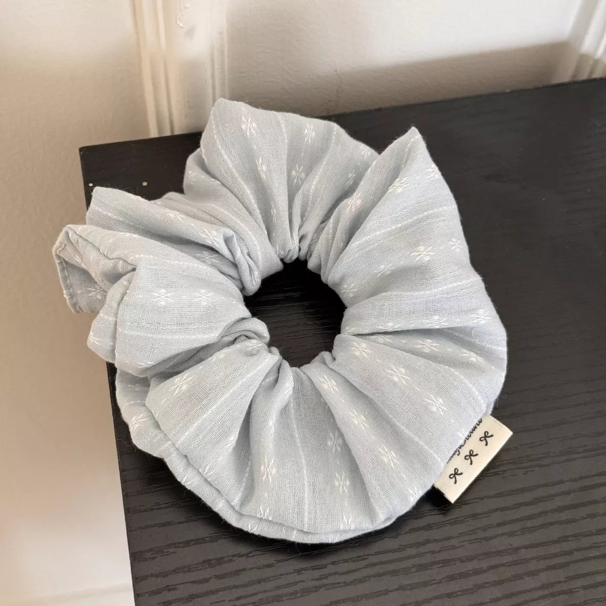 White hair scrunchie with subtle dotted pattern
