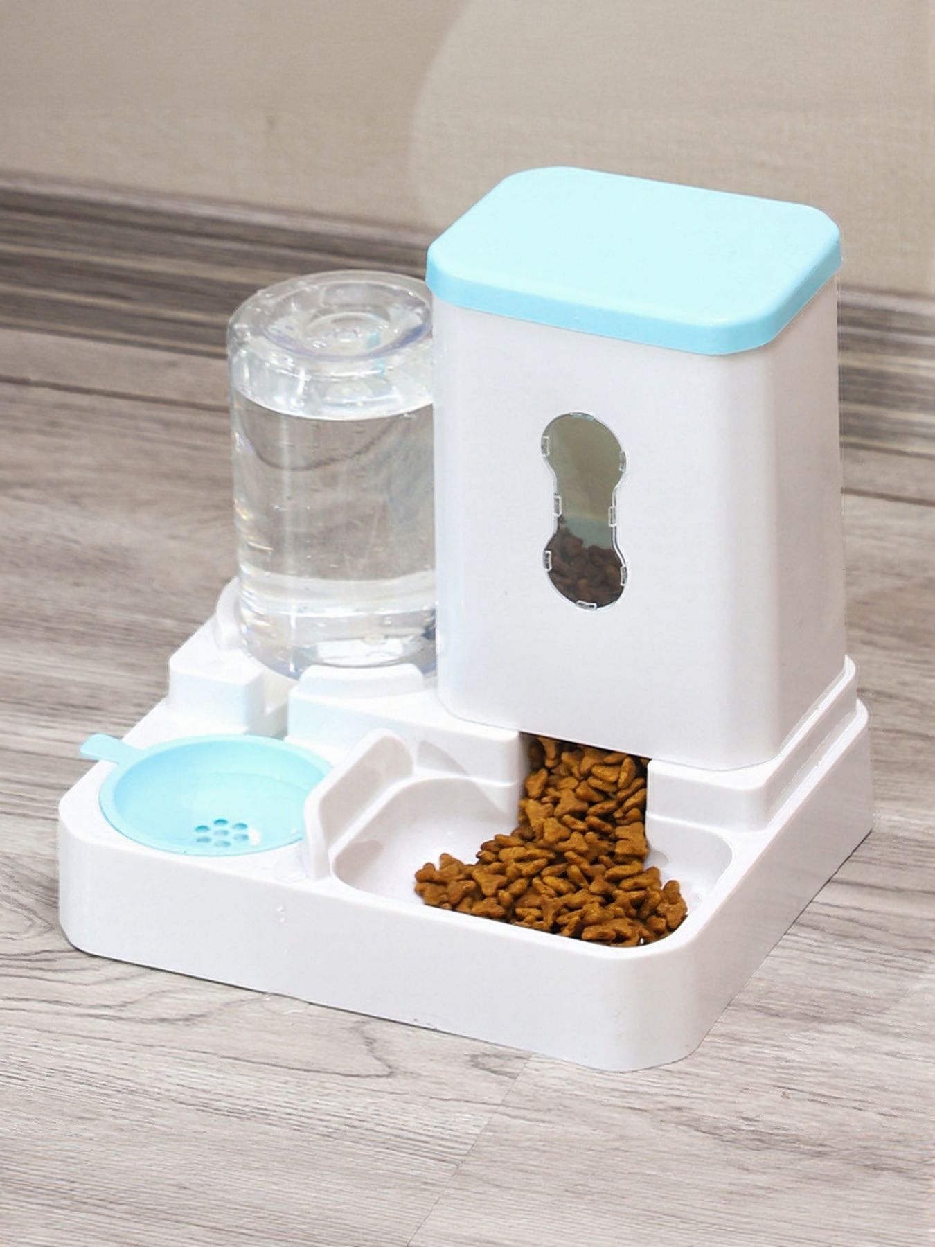 Automatic pet food and water dispenser with light blue lid, food tray and water tank.