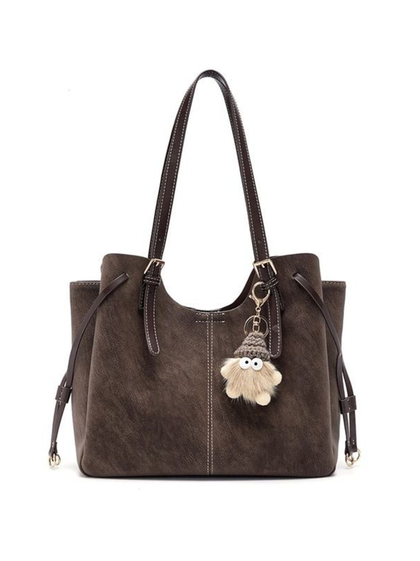 Brown shoulder bag with adjustable straps, bow detail at top, and pom keychain charm