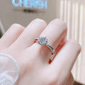 1-carat sterling silver moissanite ring on finger, round center stone and pave band