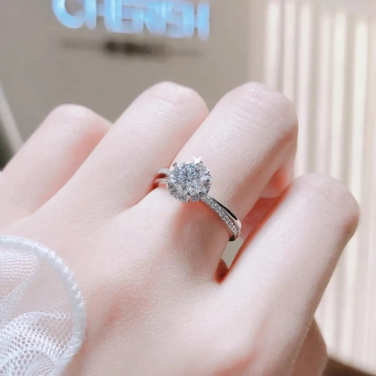 1-carat sterling silver moissanite ring on finger, round center stone and pave band