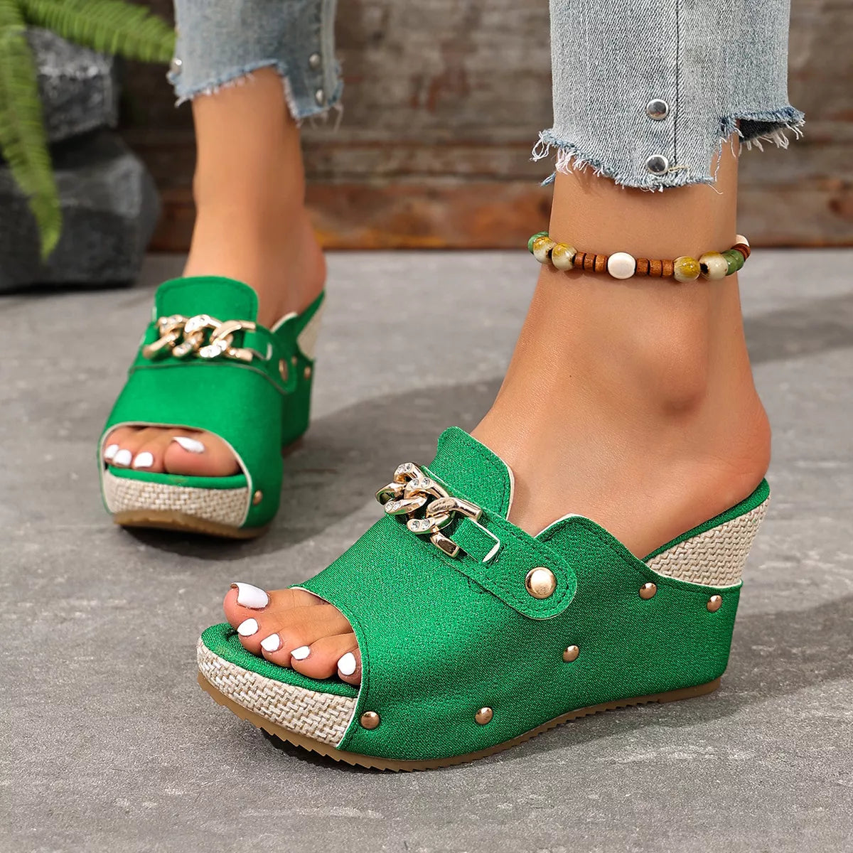 Green open-toe wedge sandals with stud accents, front strap, and metal chain hardware