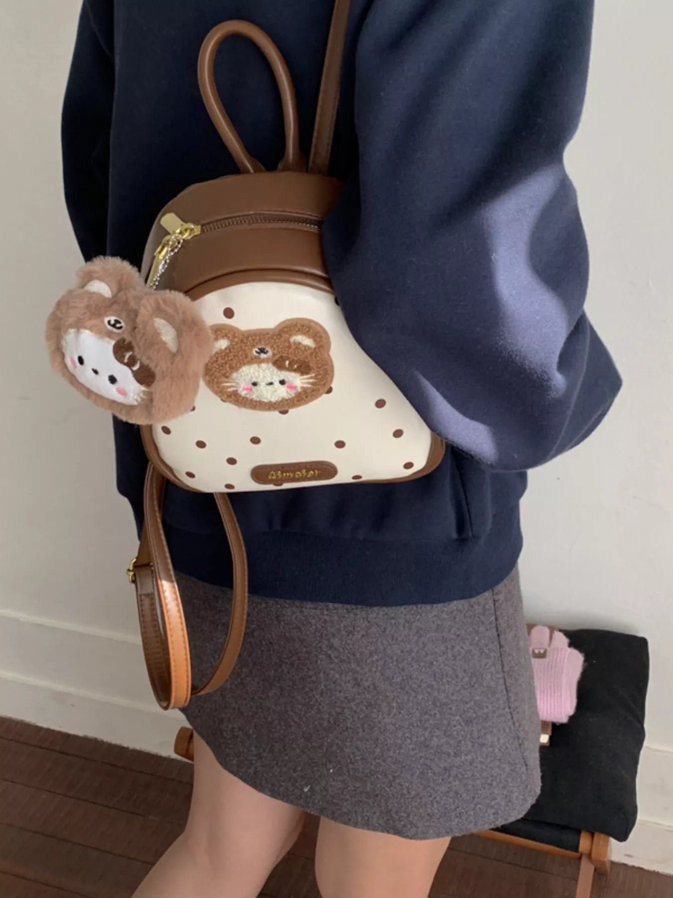 Brown cartoon bear backpack bag with white dotted front panel and plush bear keychain