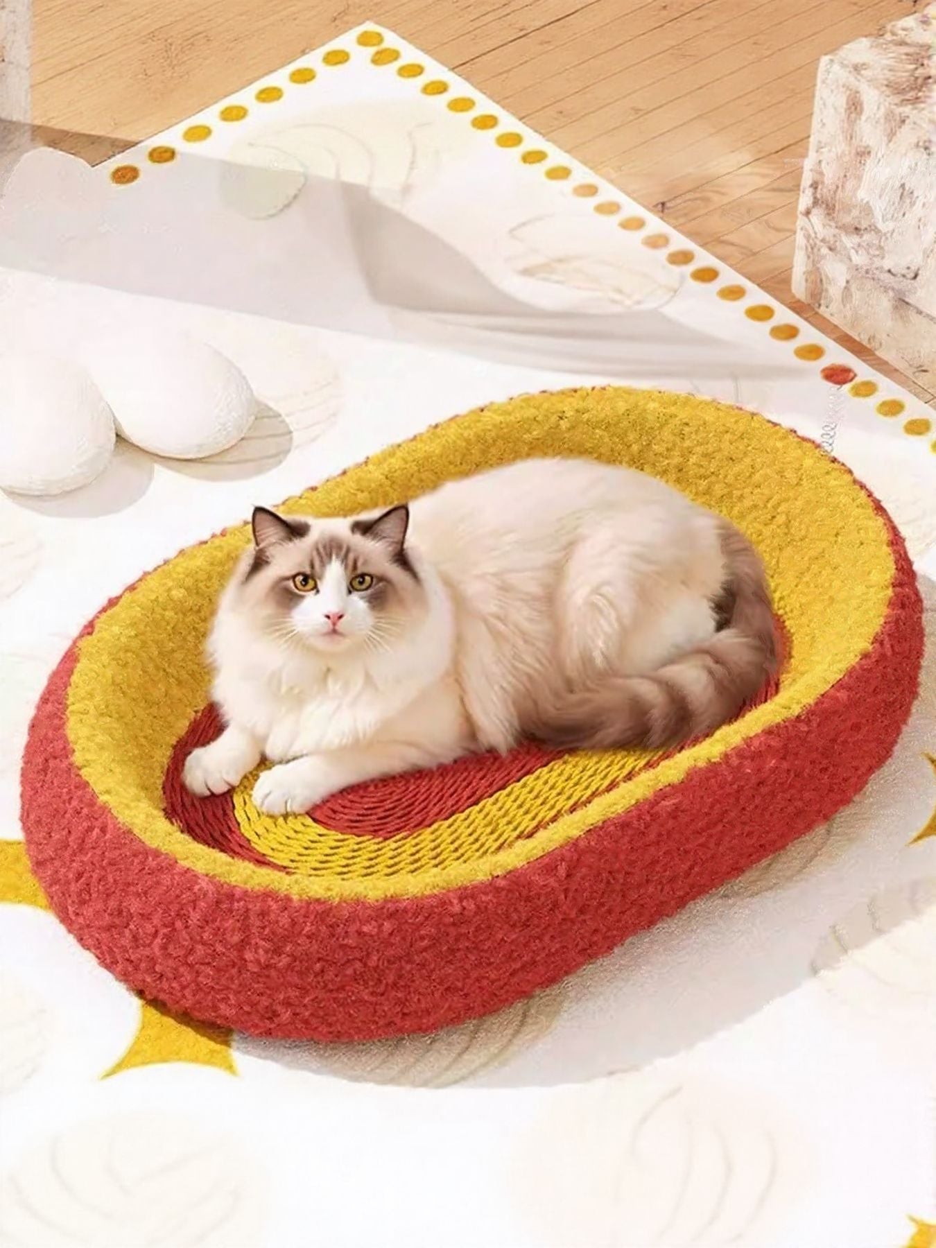 Oval cat scratching bed in red with yellow-and-red swirl; cat resting inside